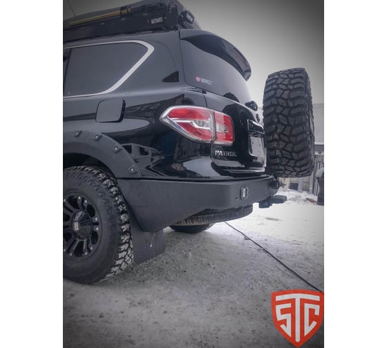Бампер силовой задний STC Nissan Patrol Y62 2014-2019 с квадратом под фаркоп, кронштейном крепления запасного колеса по центру, кронштейном крепления гос номера и фарами заднего хода/ПТФ STC-NPY62/14-BR-C1-L2