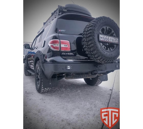 Бампер силовой задний STC Nissan Patrol Y62 2010-2014 с квадратом под фаркоп, кронштейном крепления запасного колеса по центру, кронштейном крепления гос номера и фарами заднего хода/ПТФ STC-NPY62-BR-C1-L2